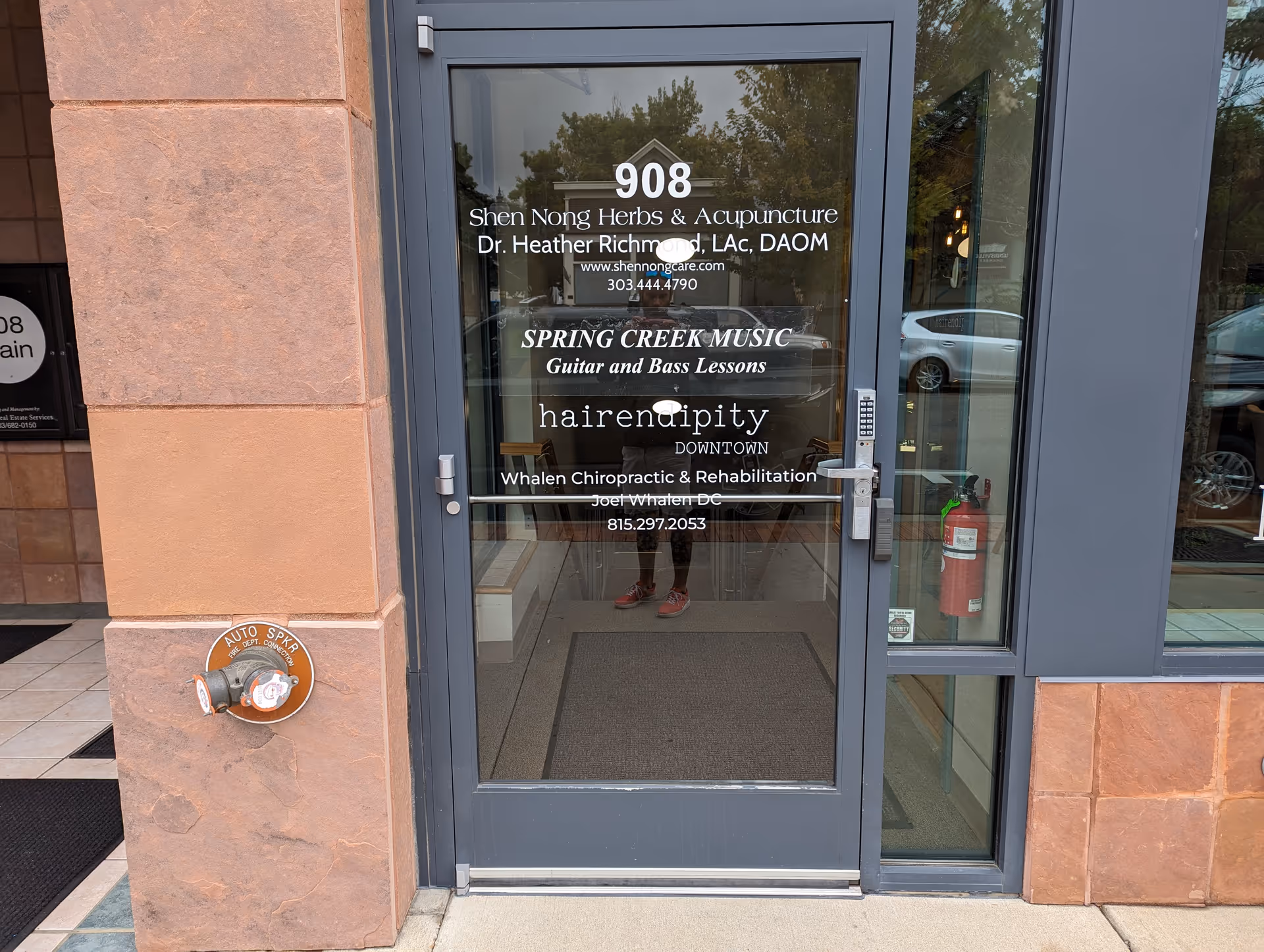 Glass storefront door displaying business names and the number 908.