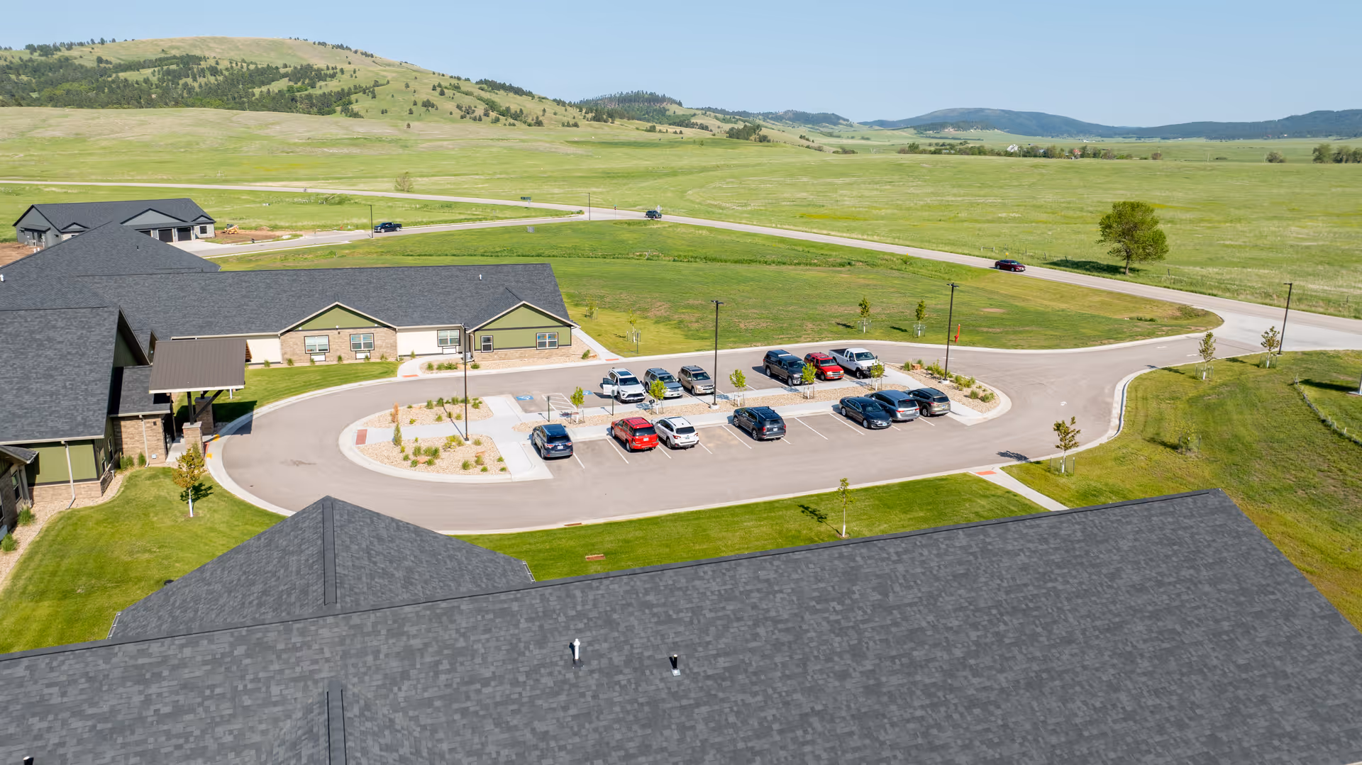 Aerial view of Peaceful Pines Senior Living at Spearfish with parking lot and open fields