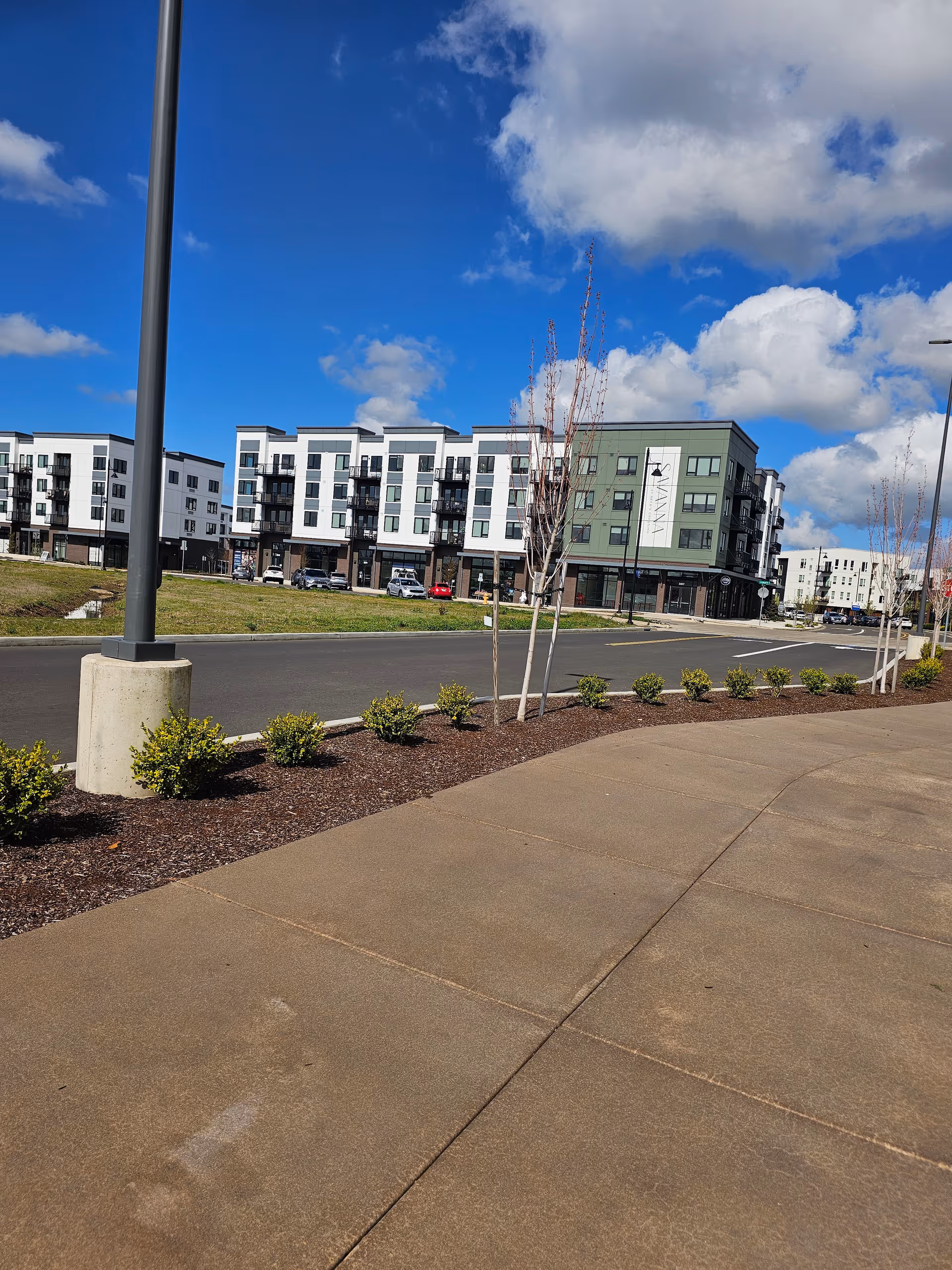 Exterior view of The Ackerly at Reed's Crossing senior living complex with parked cars.