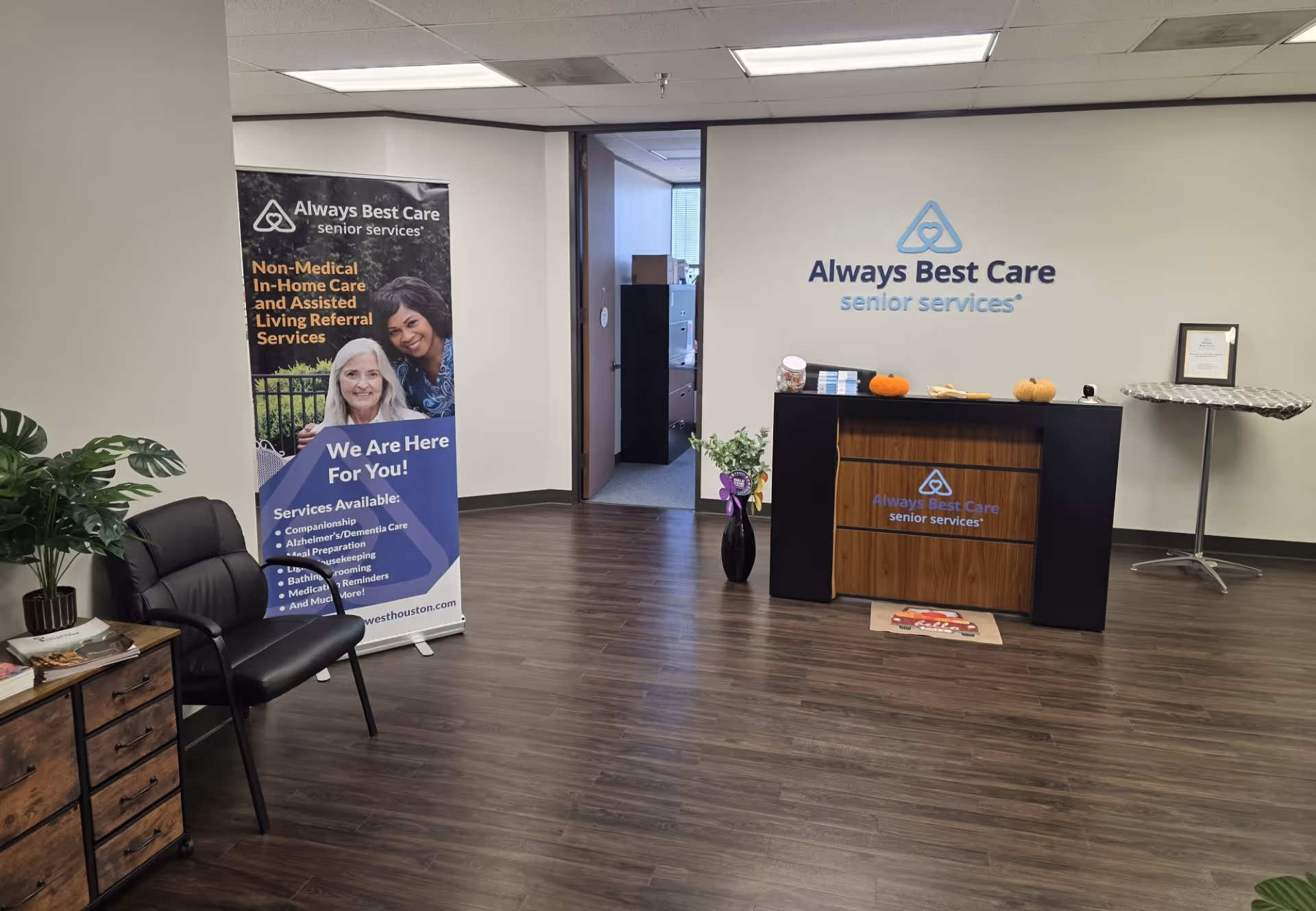 Reception area of Always Best Care with desk, banner, and seating.