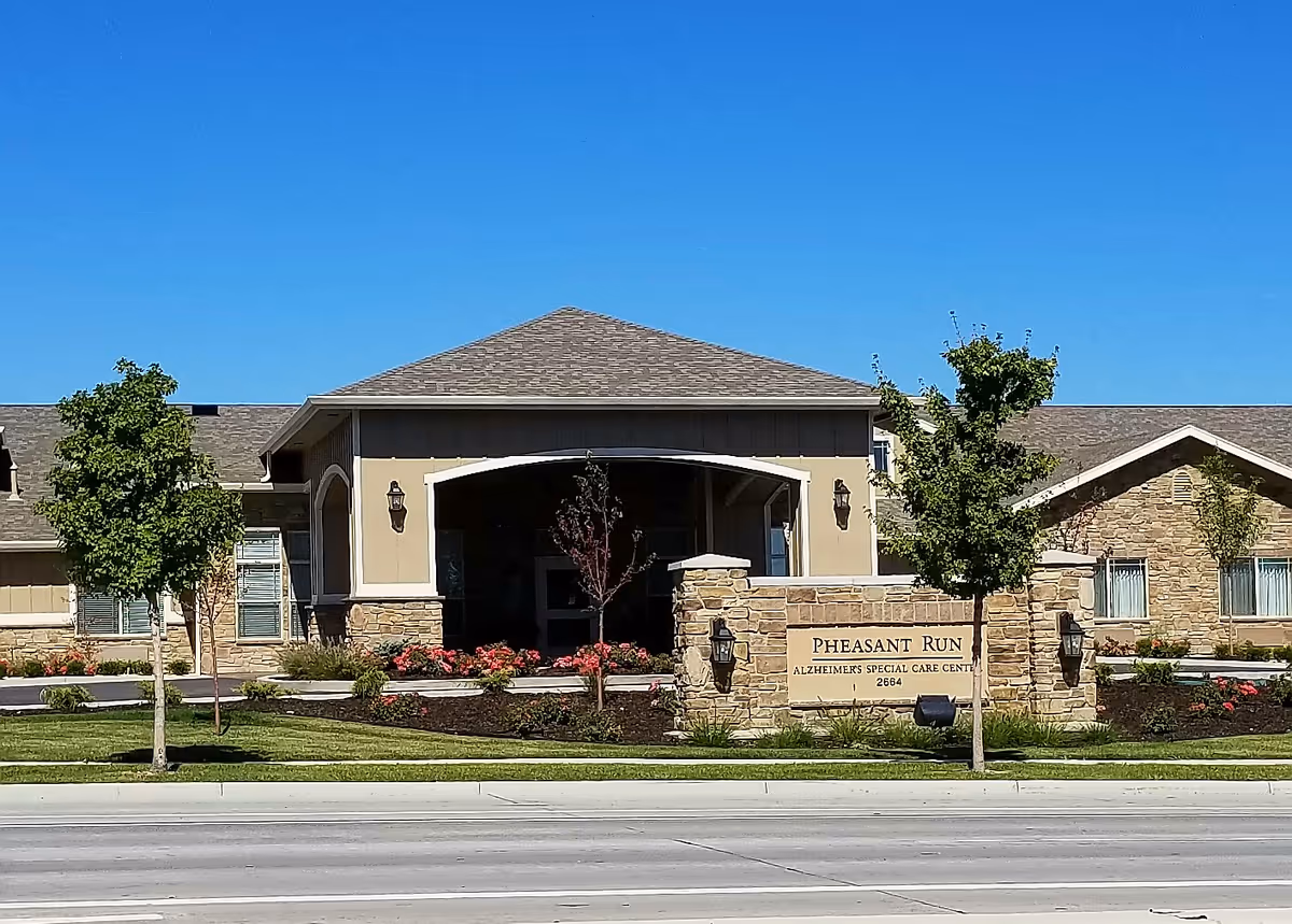 Front exterior of a senior living center with stone entrance and landscaping.