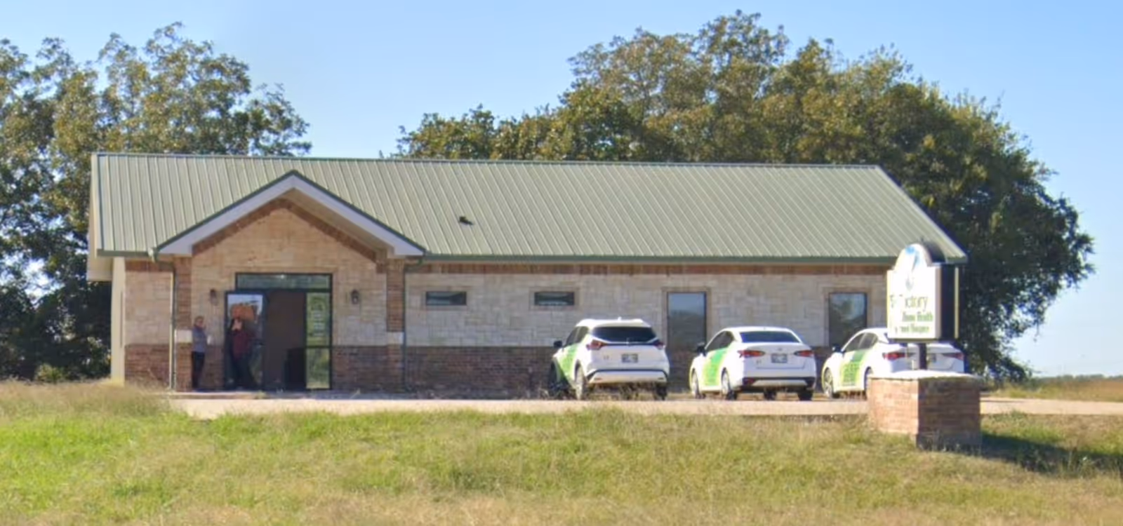 Front view of a single-story Victory Home Health & Hospice building with parked cars.
