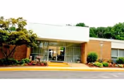 Exterior view of Vierra Falls Church front entrance with glass doors and landscaping.