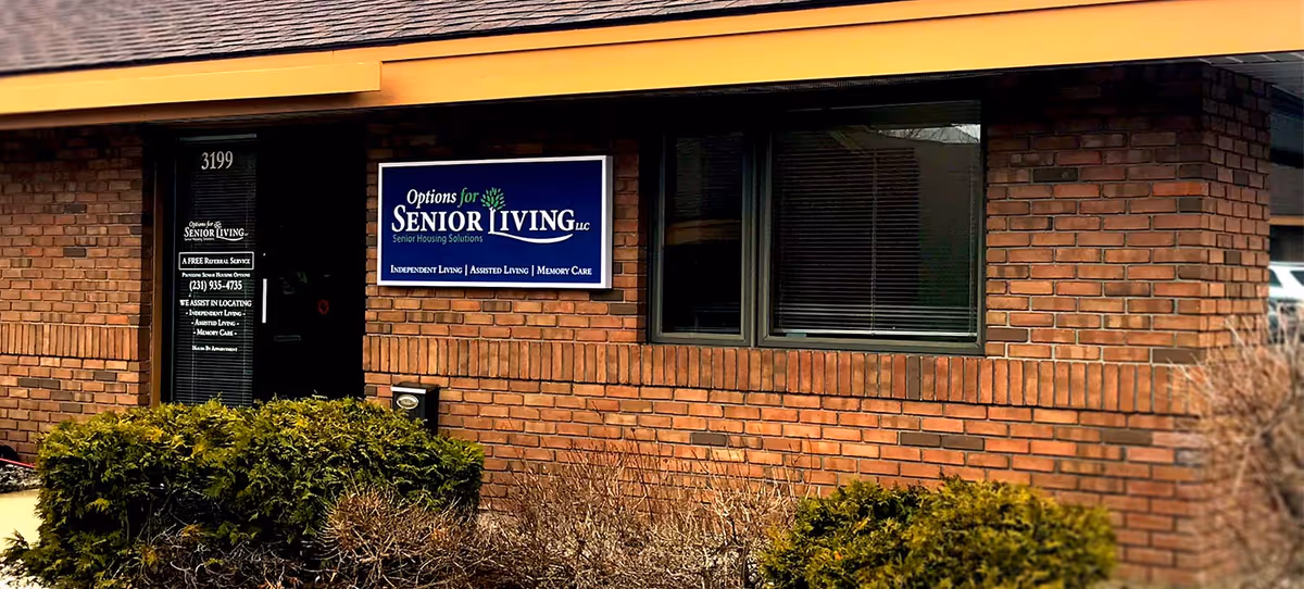 Exterior view of a brick senior living building with a blue Options for Senior Living sign.