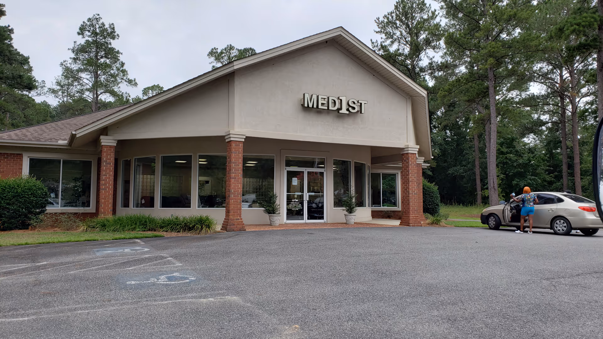 Exterior view of Med1st senior living facility with entrance and parking lot.