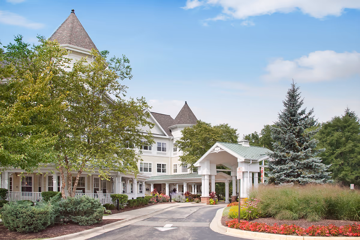Sunrise of Schaumburg building front with entrance canopy and manicured landscaping.
