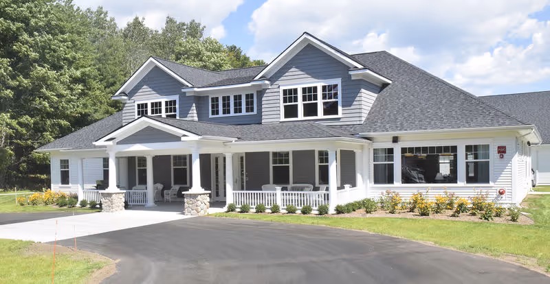 Pineview Cottage exterior: a white two-story building with a welcoming front porch.