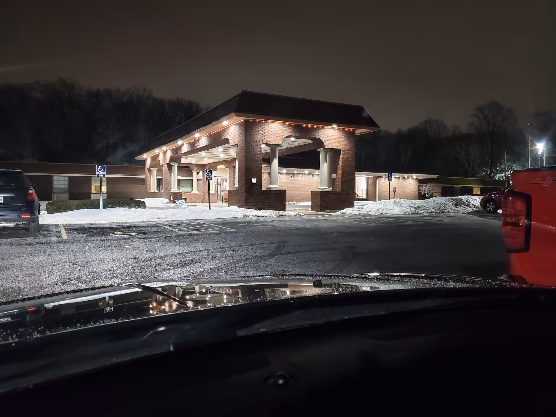 Night exterior view of a brick entrance canopy at Continuing Healthcare at the Ridge.