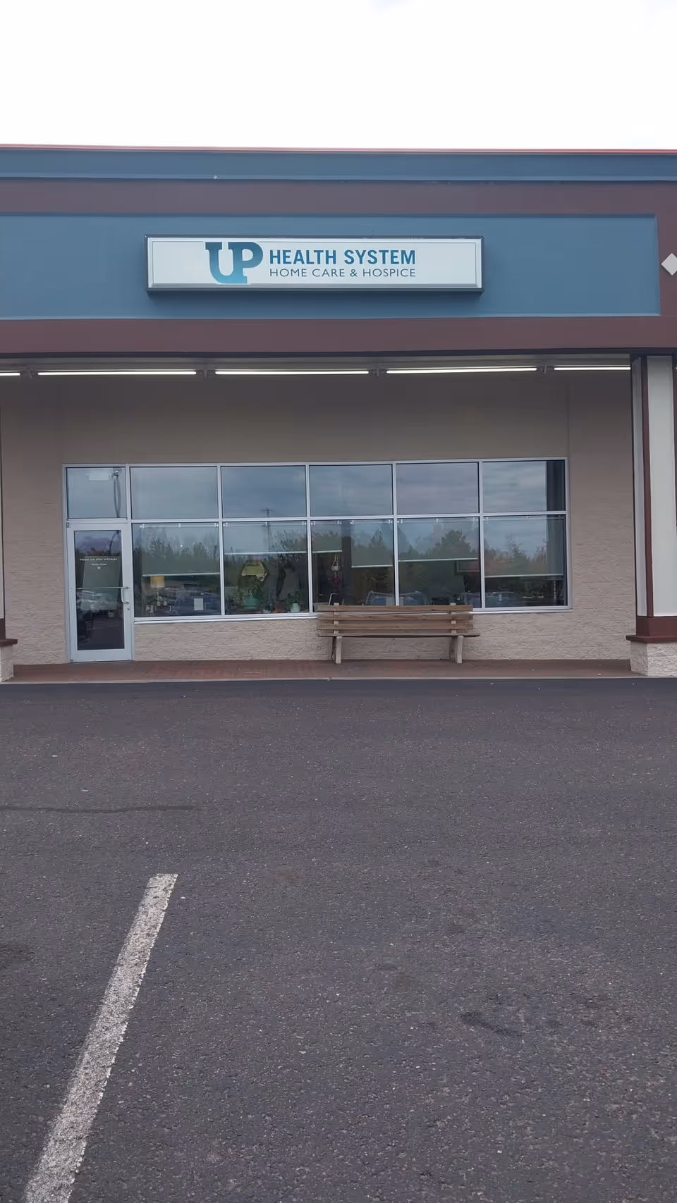 Front view of UP Health System Home Care & Hospice Portage building with bench