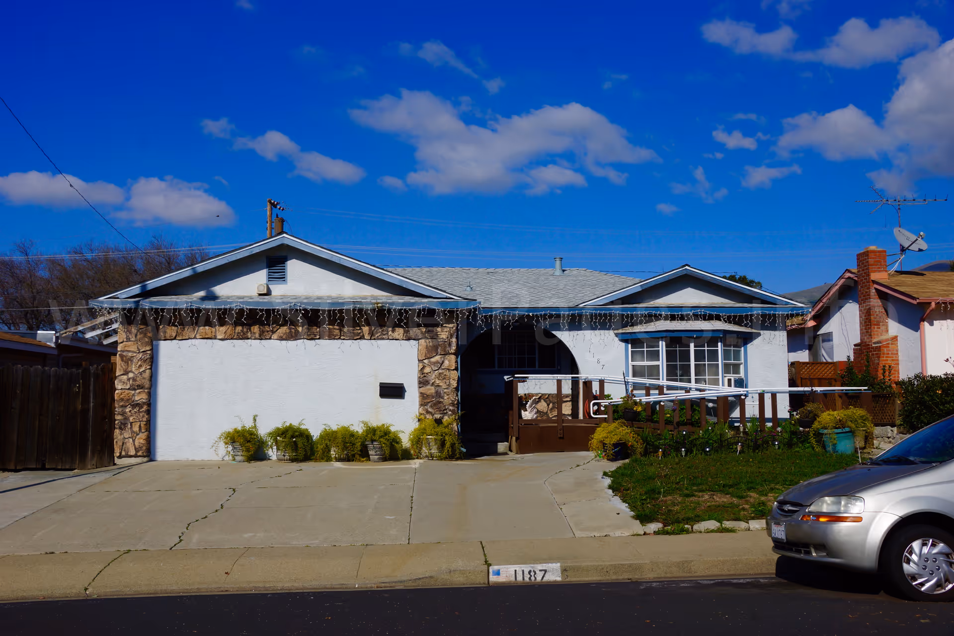 Front view of a single-story care home with driveway and parked car.