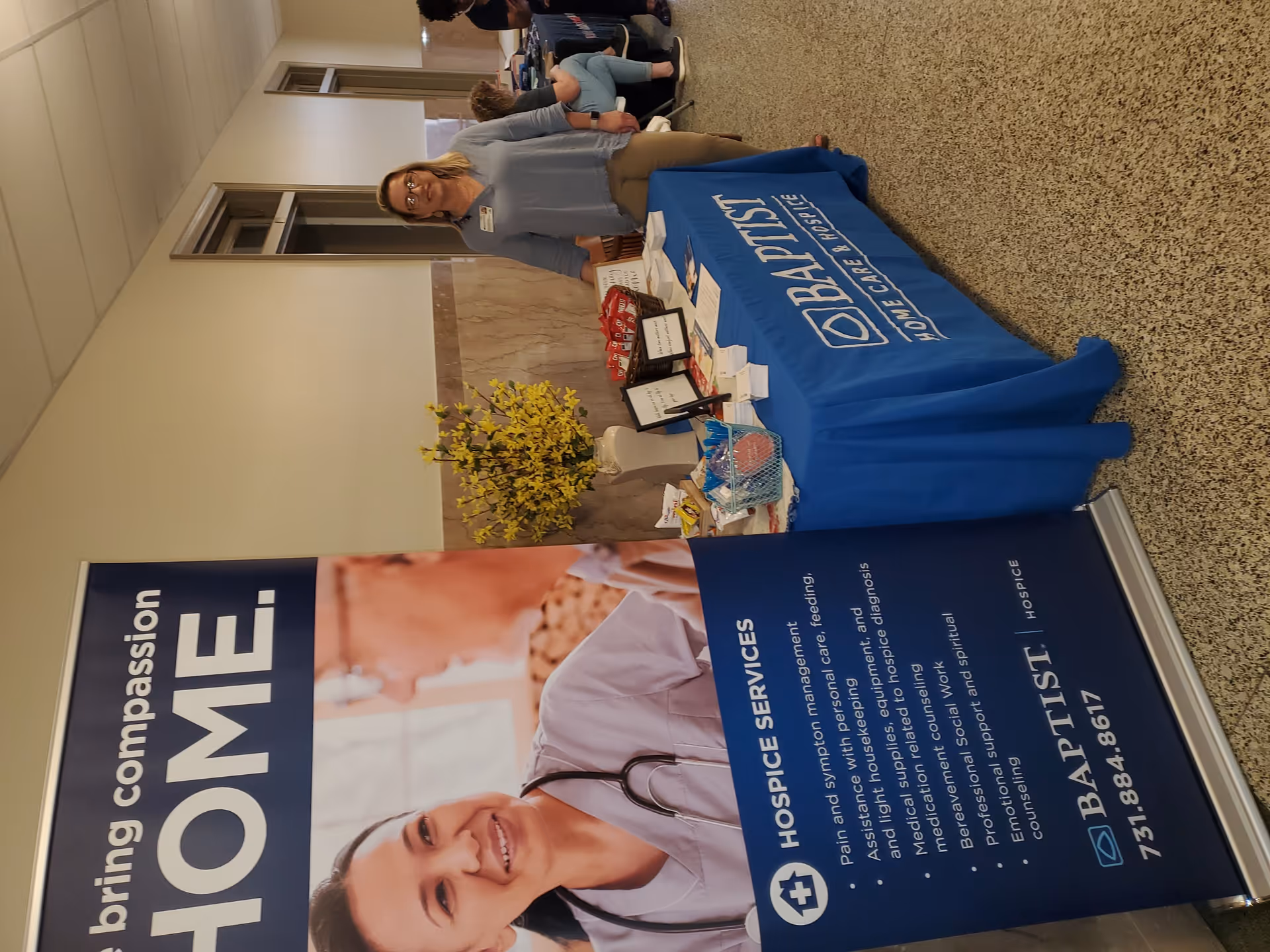 A Baptist Home Care and Hospice booth set up in an indoor hallway.