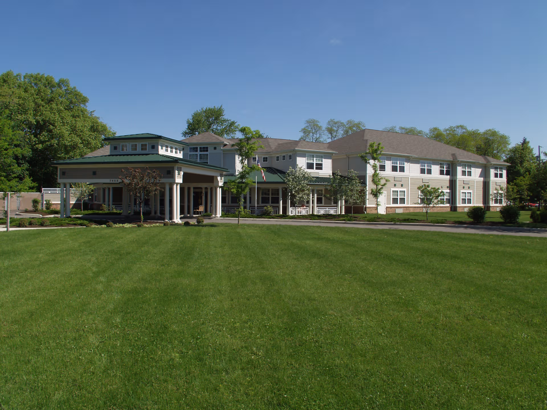 Front view of Salida Woods senior living building with expansive green lawn.