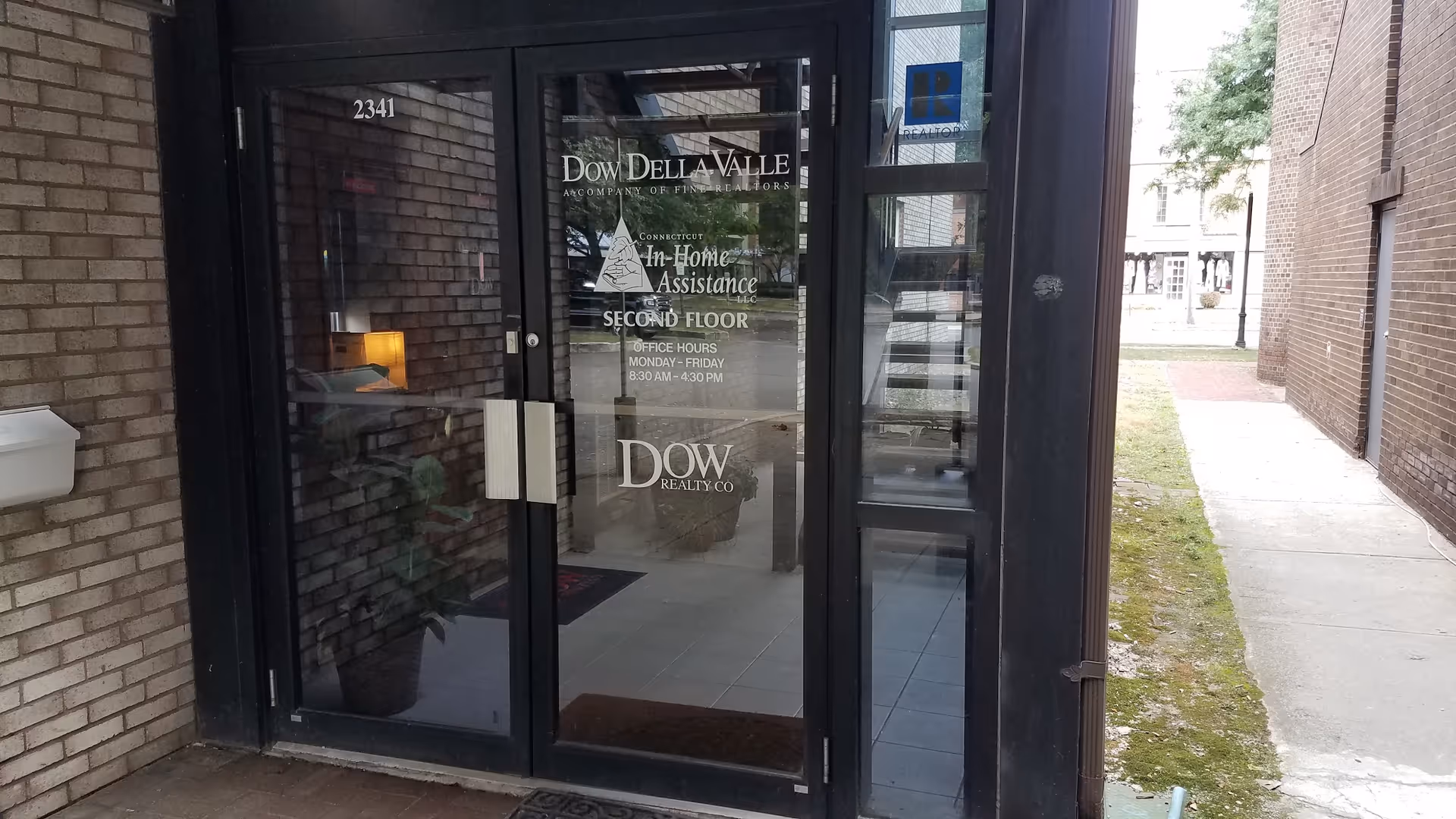 Front entrance of a brick building with glass doors for Connecticut In-Home Assistance.