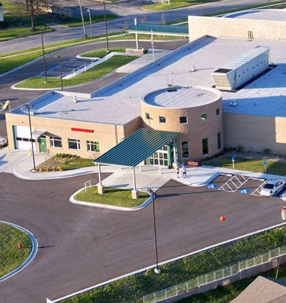 Aerial view of Pershing Memorial Hospital exterior with circular entrance and large parking lot.