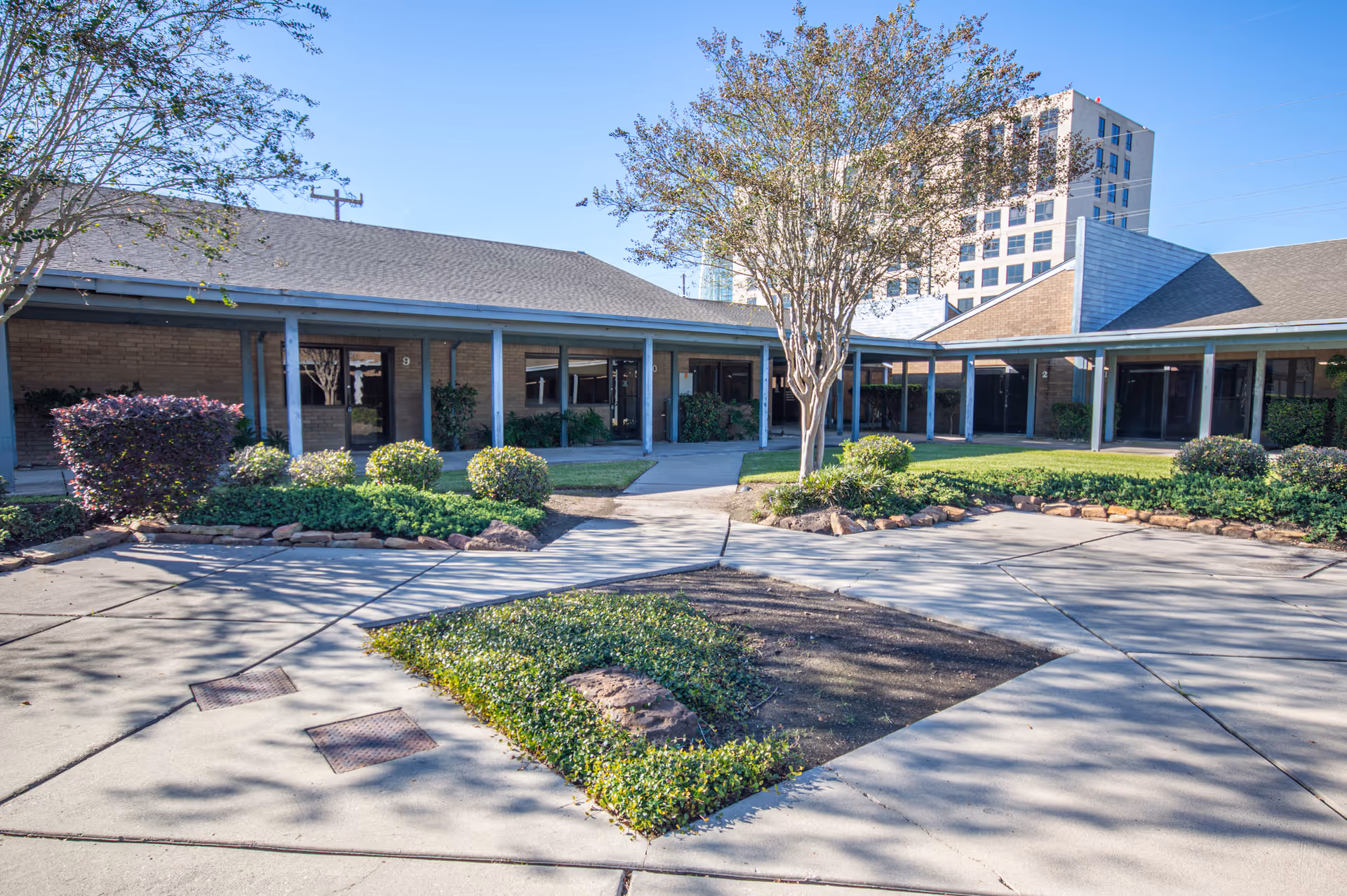 Exterior view of Magnificat Home Healthcare Services facility with covered walkway and landscaped courtyard.