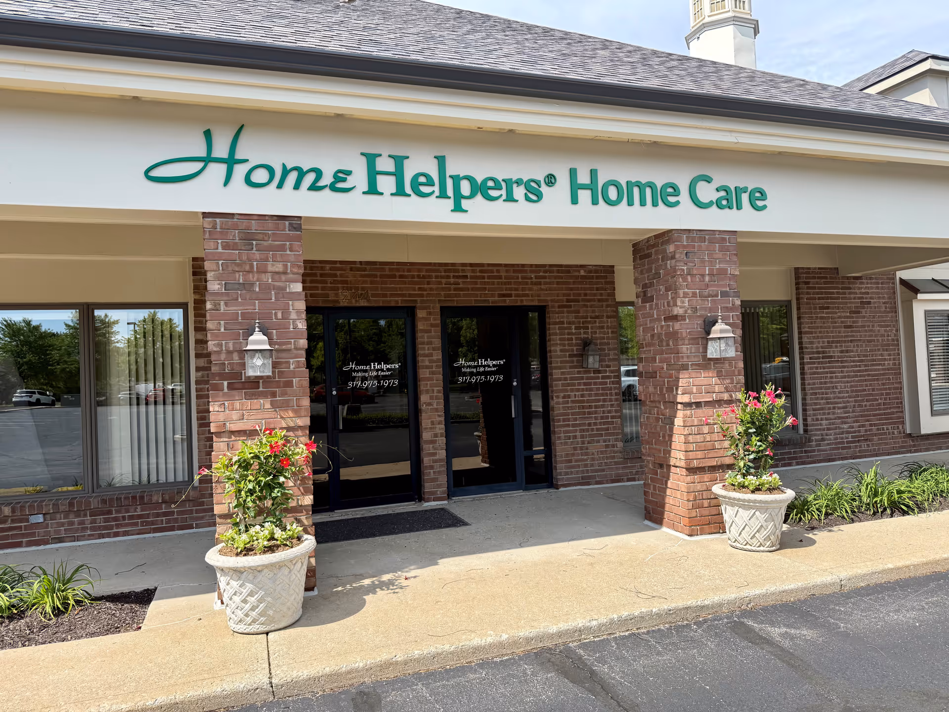 Exterior view of Home Helpers Home Care building with brick columns and glass doors.