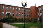 Front facade of Franklin Court Assisted Living, a brick building with lawn and lampposts.