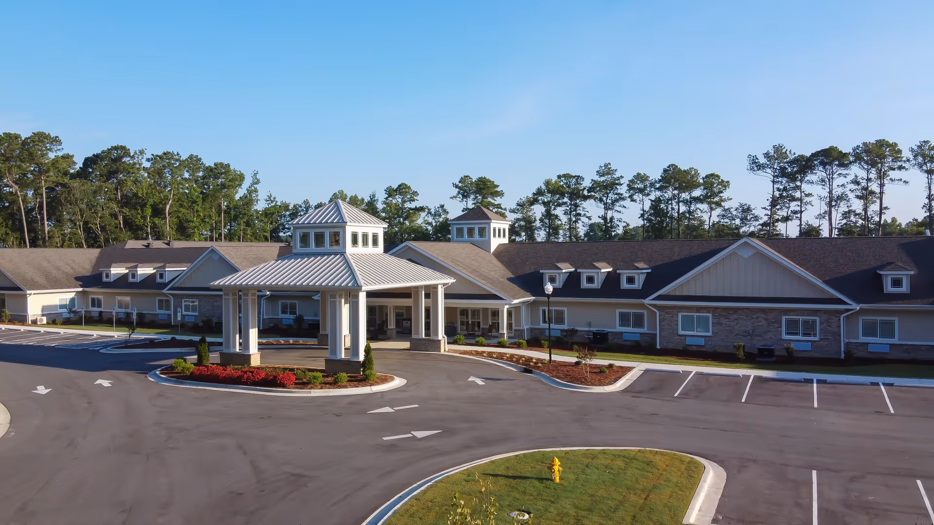Exterior view of Coastal Pointe Assisted Living and Memory Care building with circular driveway and entrance