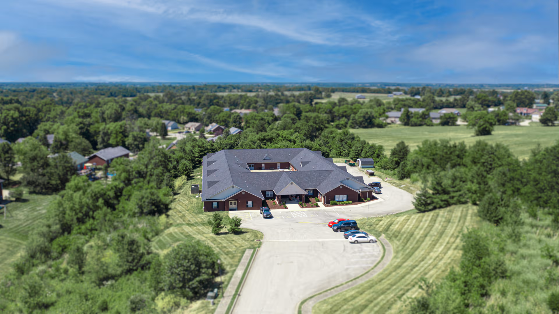 Aerial view of Aspen Alcove Bardstown facility with parking among trees.