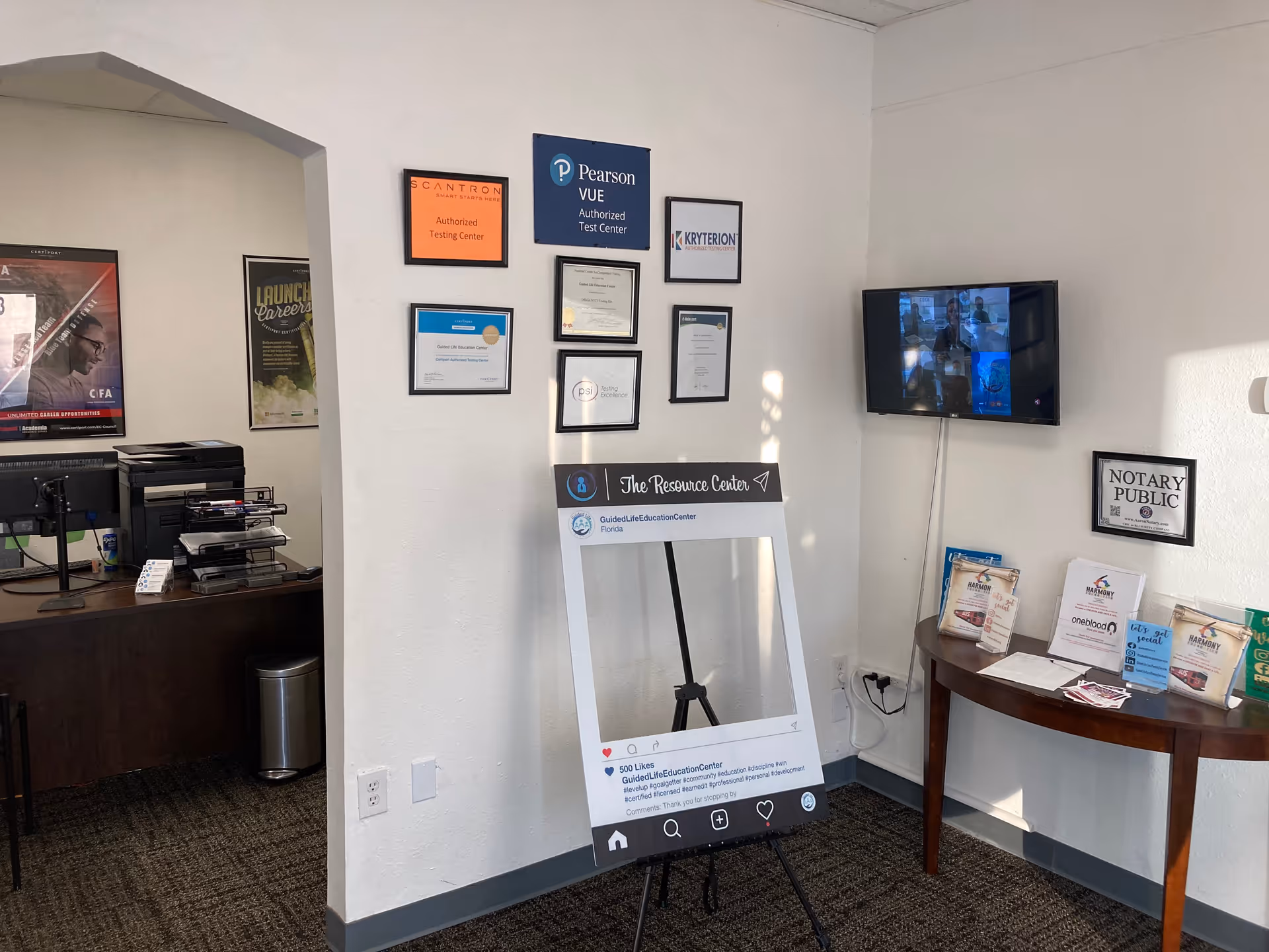 Interior lobby area with framed certificates, a TV, and a large photo frame display.
