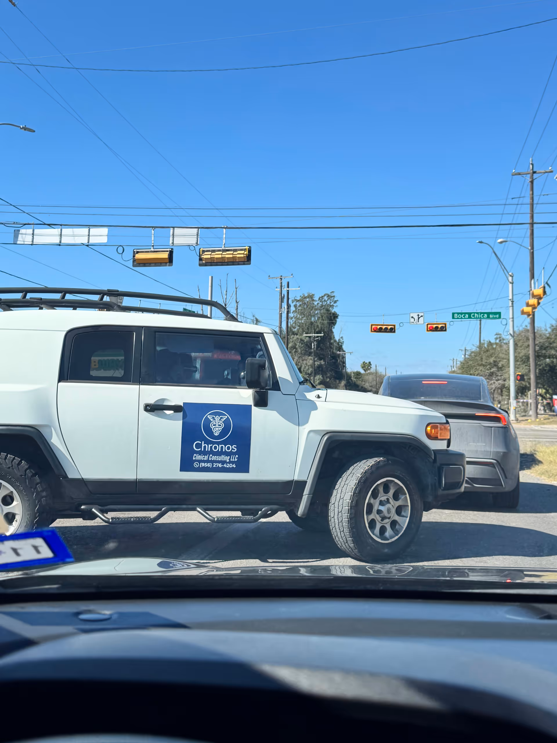 White SUV with Chronos Clinical Consulting LLC logo at an intersection.
