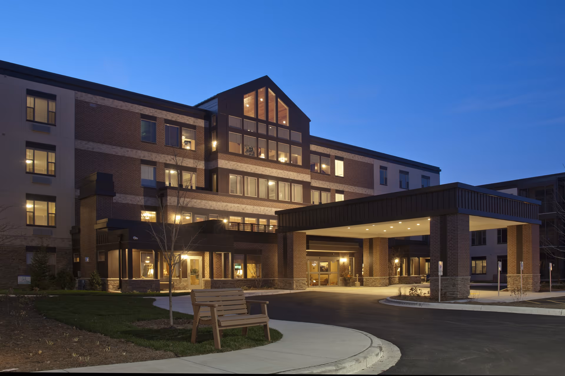 Exterior view of New Perspective Senior Living West Bend with illuminated front entrance
