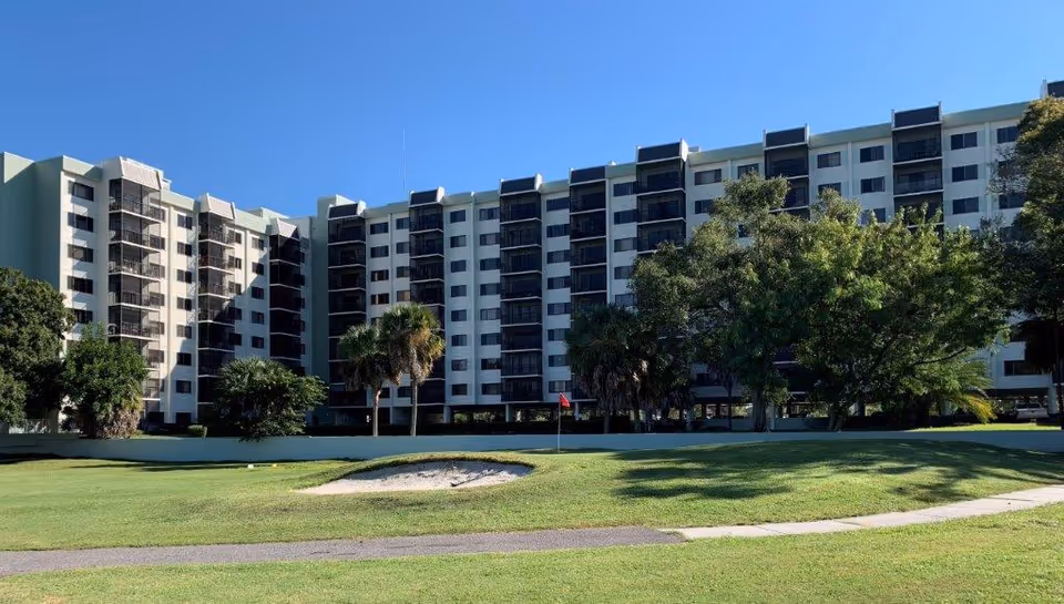 Exterior view of Elison Senior Living of Pinecrest; a multi-story building with balconies and lawn.