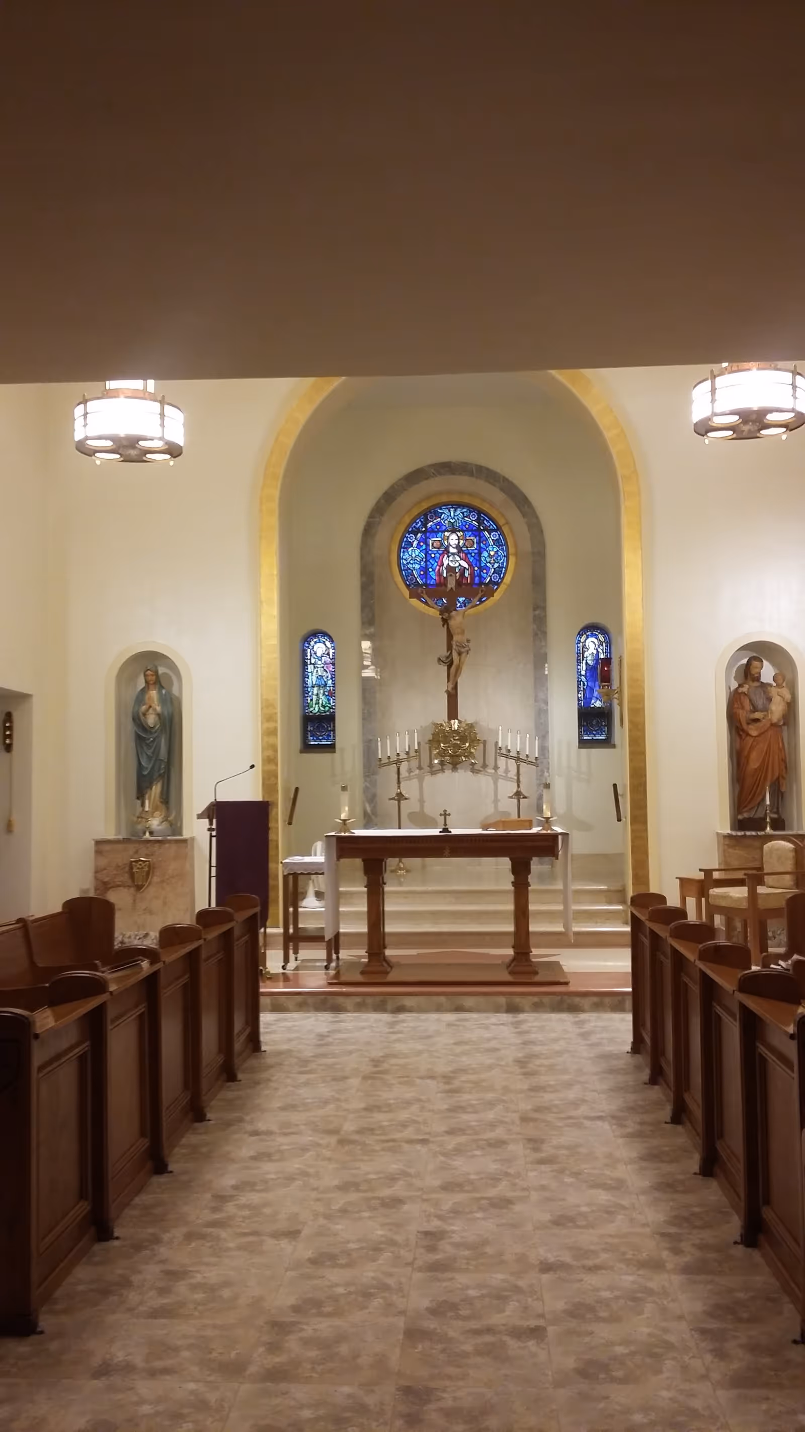 Inside a chapel at Sacred Heart Free Home with altar, crucifix, and pews.