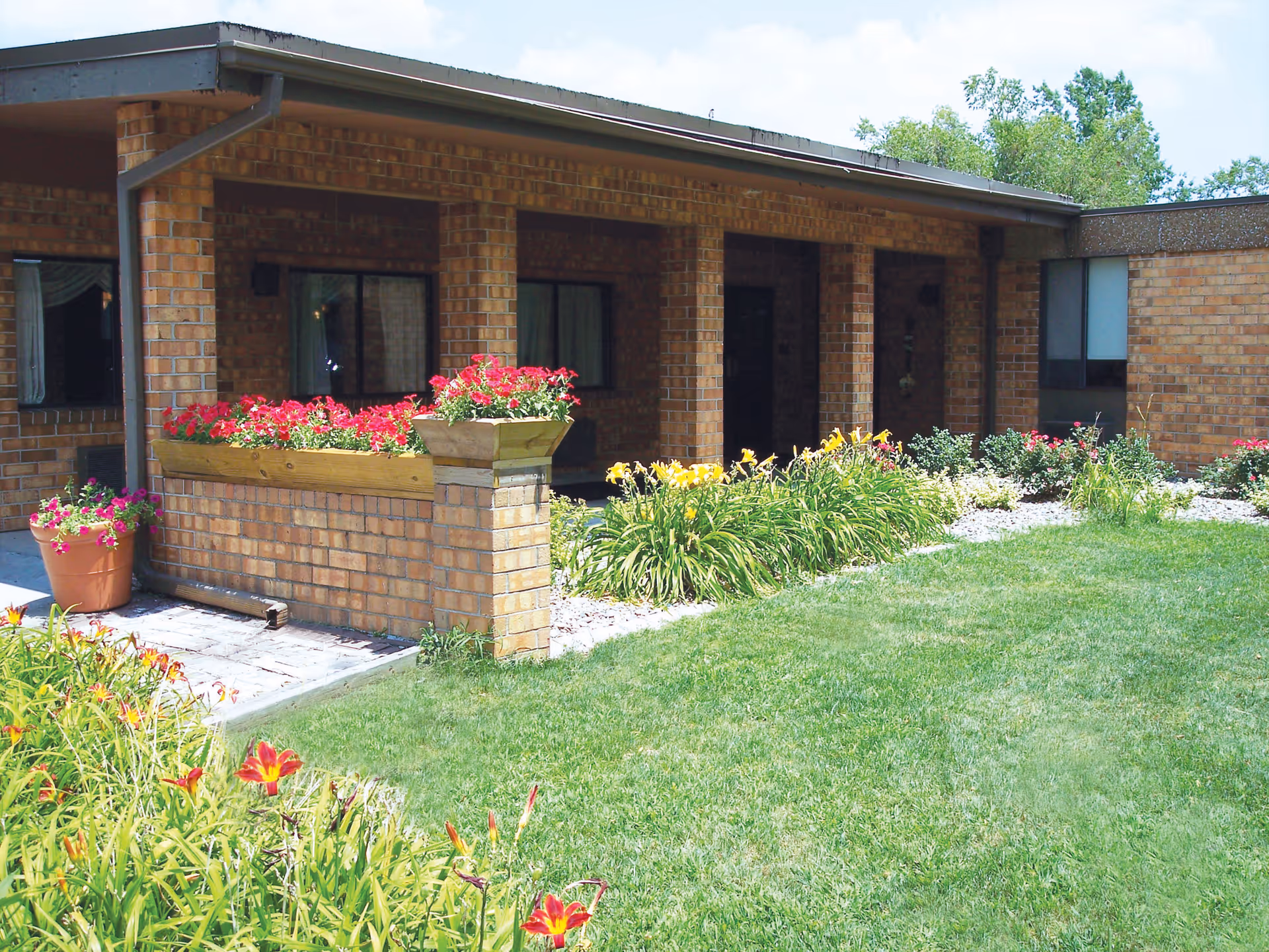 Brick exterior of Lakeside Health & Rehab Center with flower planters and a manicured lawn.