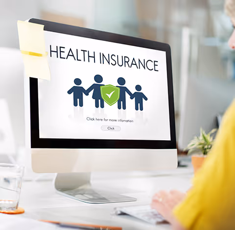 Computer monitor displays a Health Insurance graphic with stick figures and a shield.