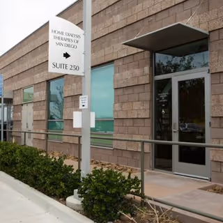 Exterior view of Home Dialysis Therapies of San Diego facility entrance with sign.