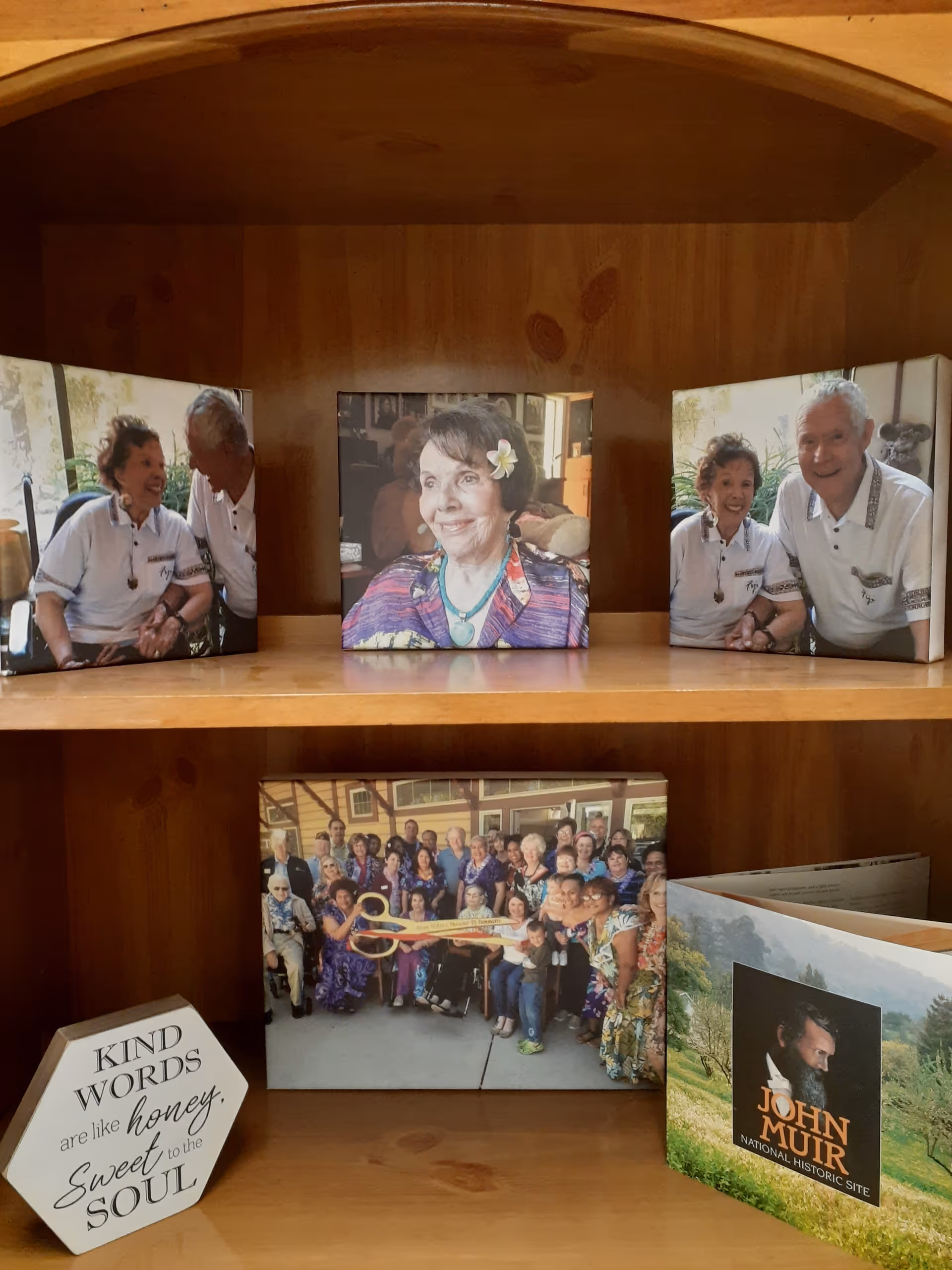 Wooden shelf displays framed photos of seniors and a decorative plaque.