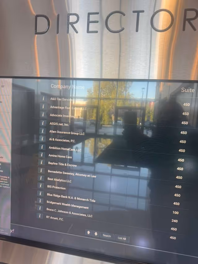 Ambition HomeCare listed among many company names on a digital directory screen in a lobby.