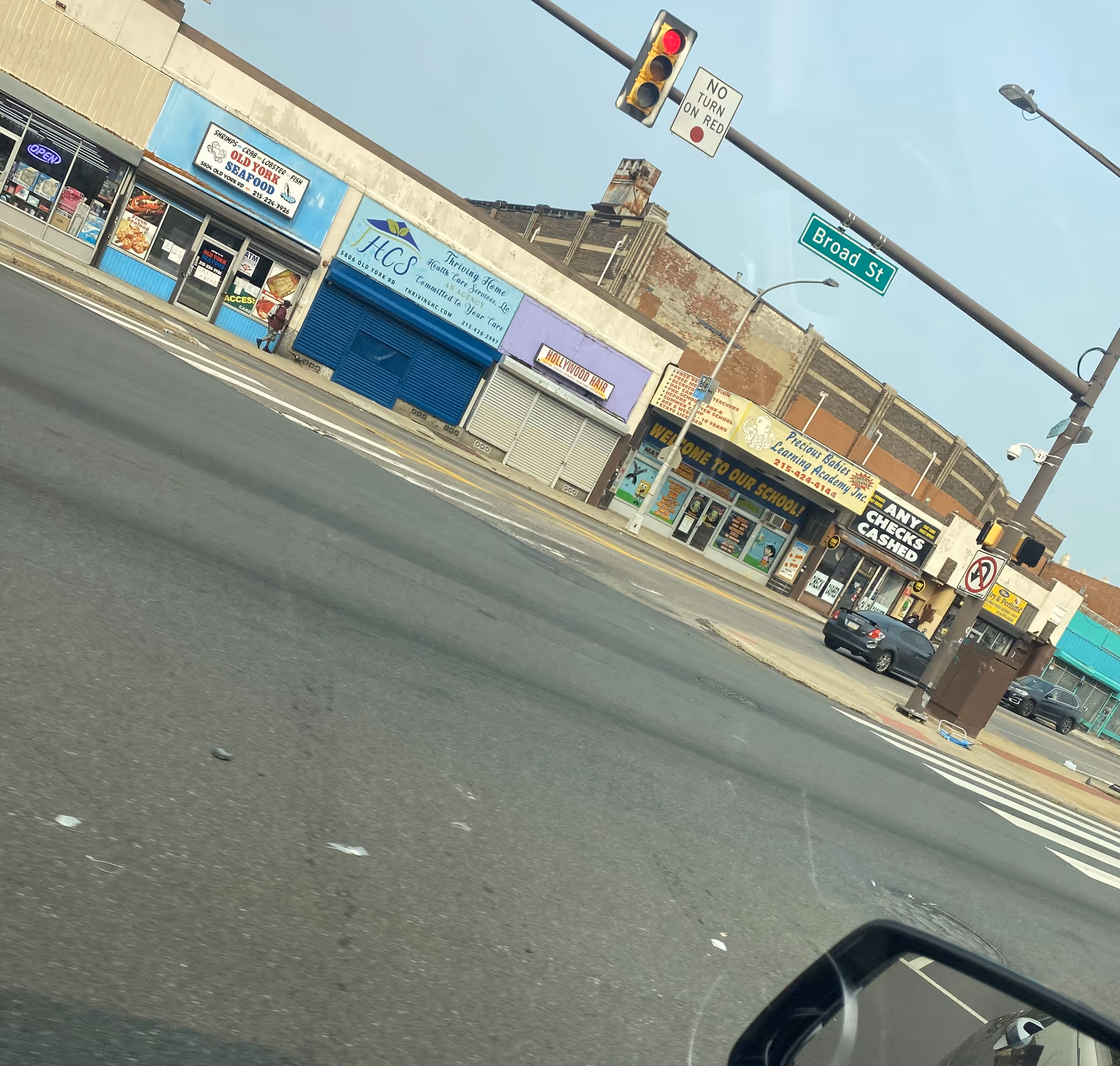 Street view of storefronts on Broad Street with closed shutters and traffic signals.