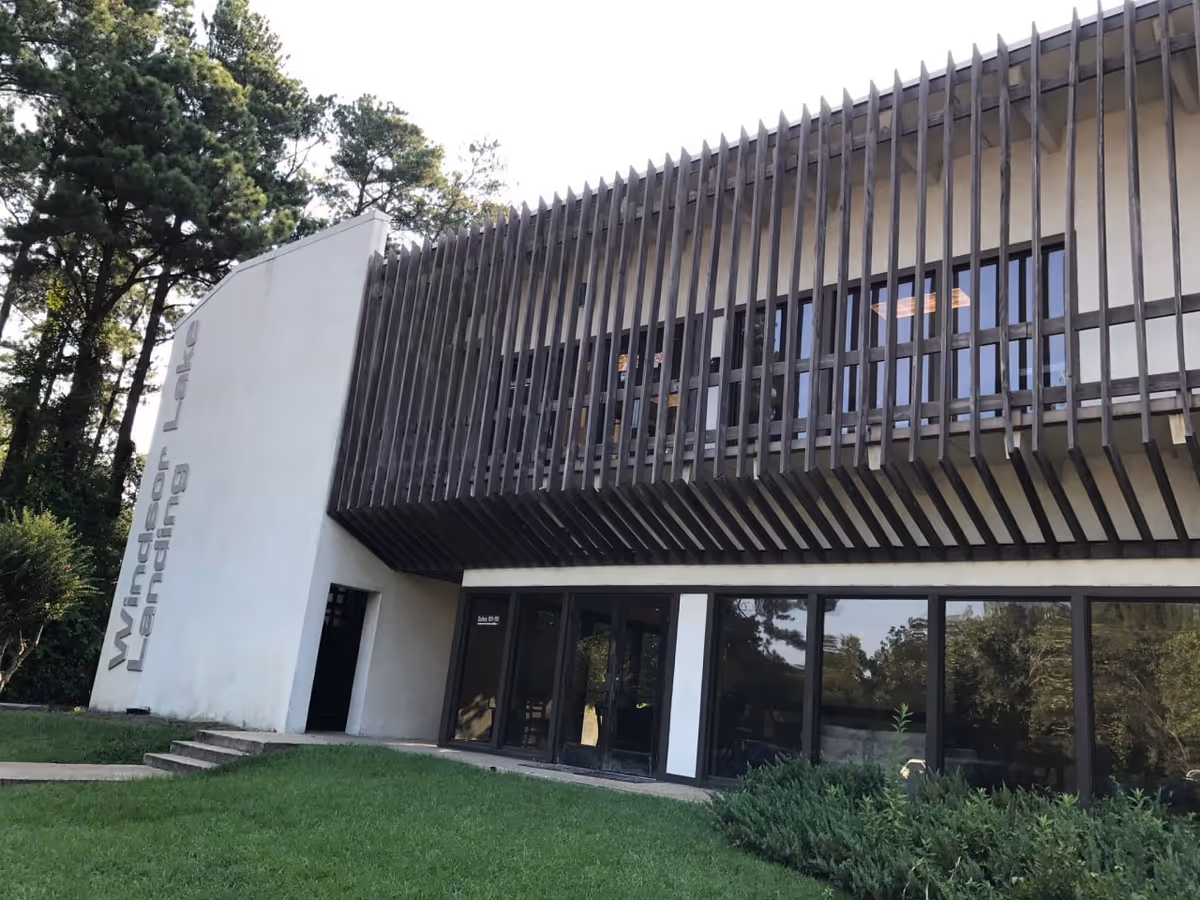 Exterior view of a modern senior care facility with glass doors and vertical slats.