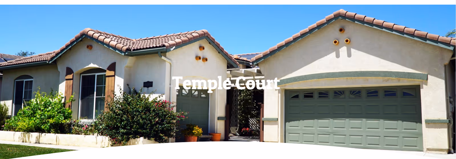 Exterior view of Temple Court Senior Care facility with landscaping and a two-car garage.