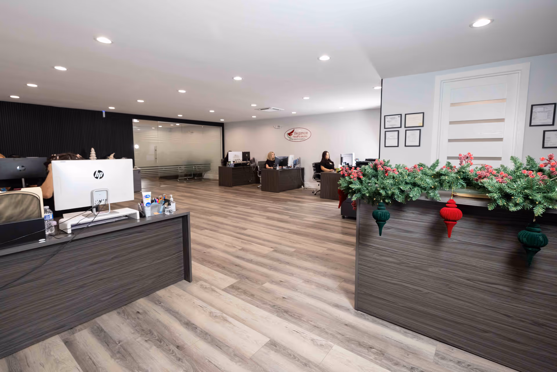 Reception desk area of a senior living lobby with staff at computers and holiday garland.