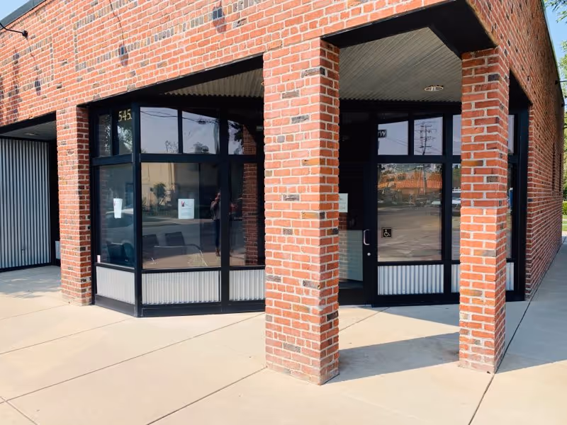 Brick building exterior with corner entrance and glass storefront at Aspire Home Healthcare - Yuba City.