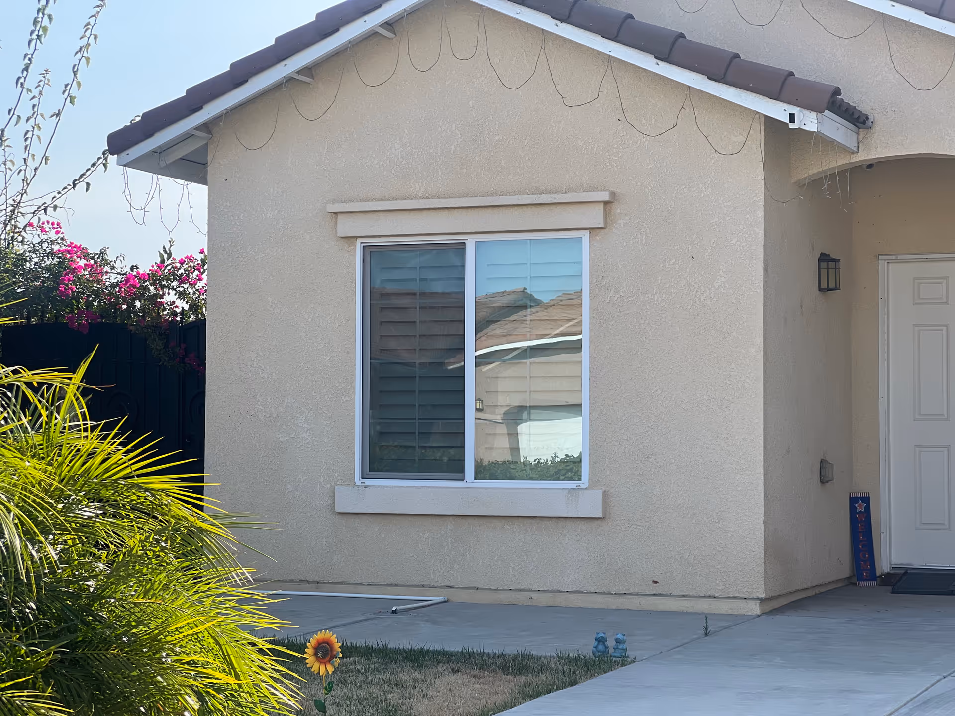 Beige stucco senior care home exterior with window and front door.