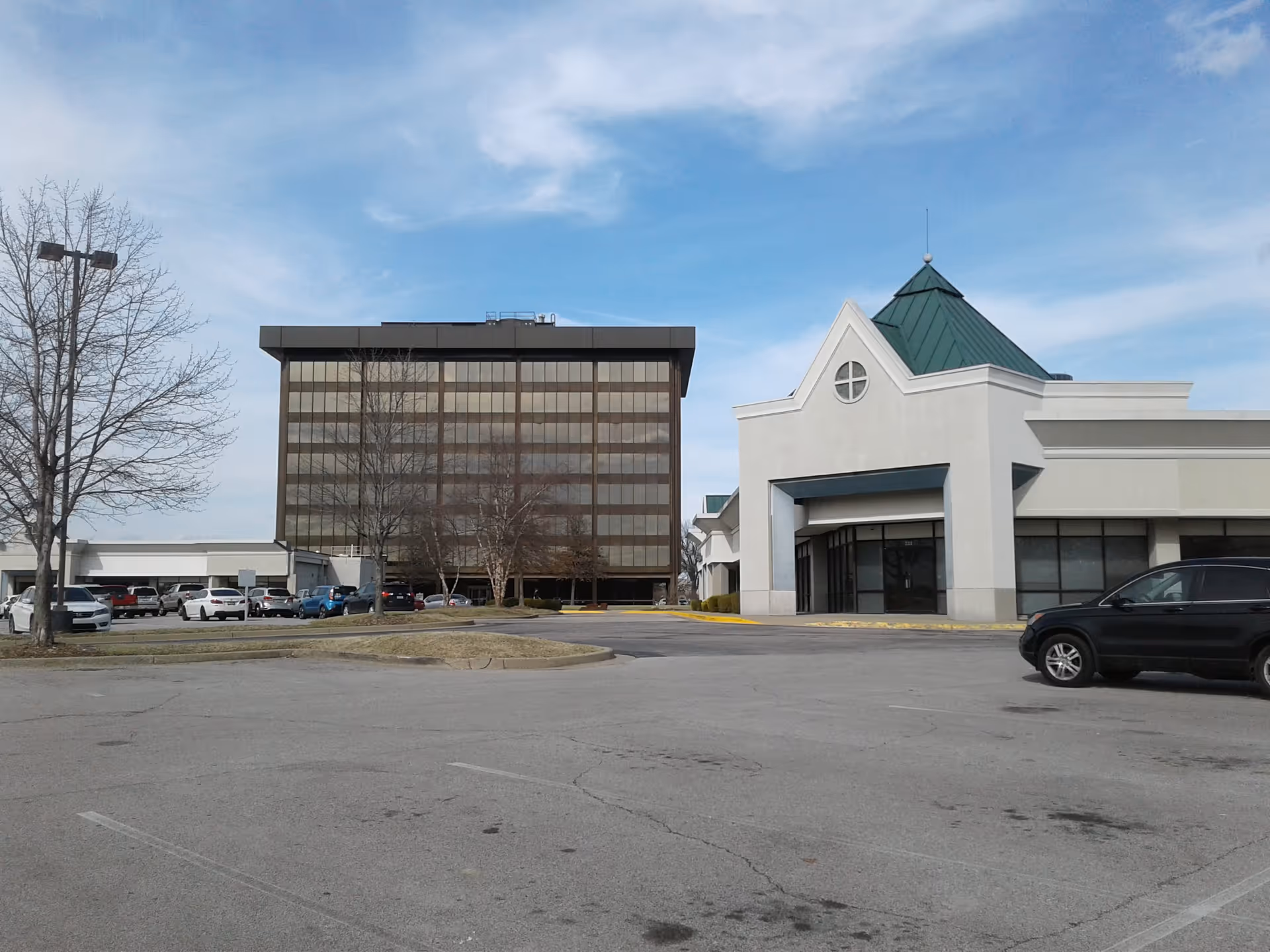 Exterior view of Abode Care Partners facility with a parking lot and modern entrance