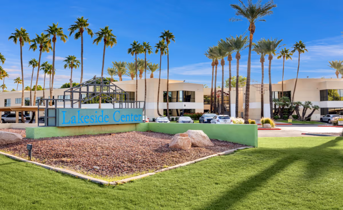 Front view of Lakeside Center exterior with palm trees and blue sky.