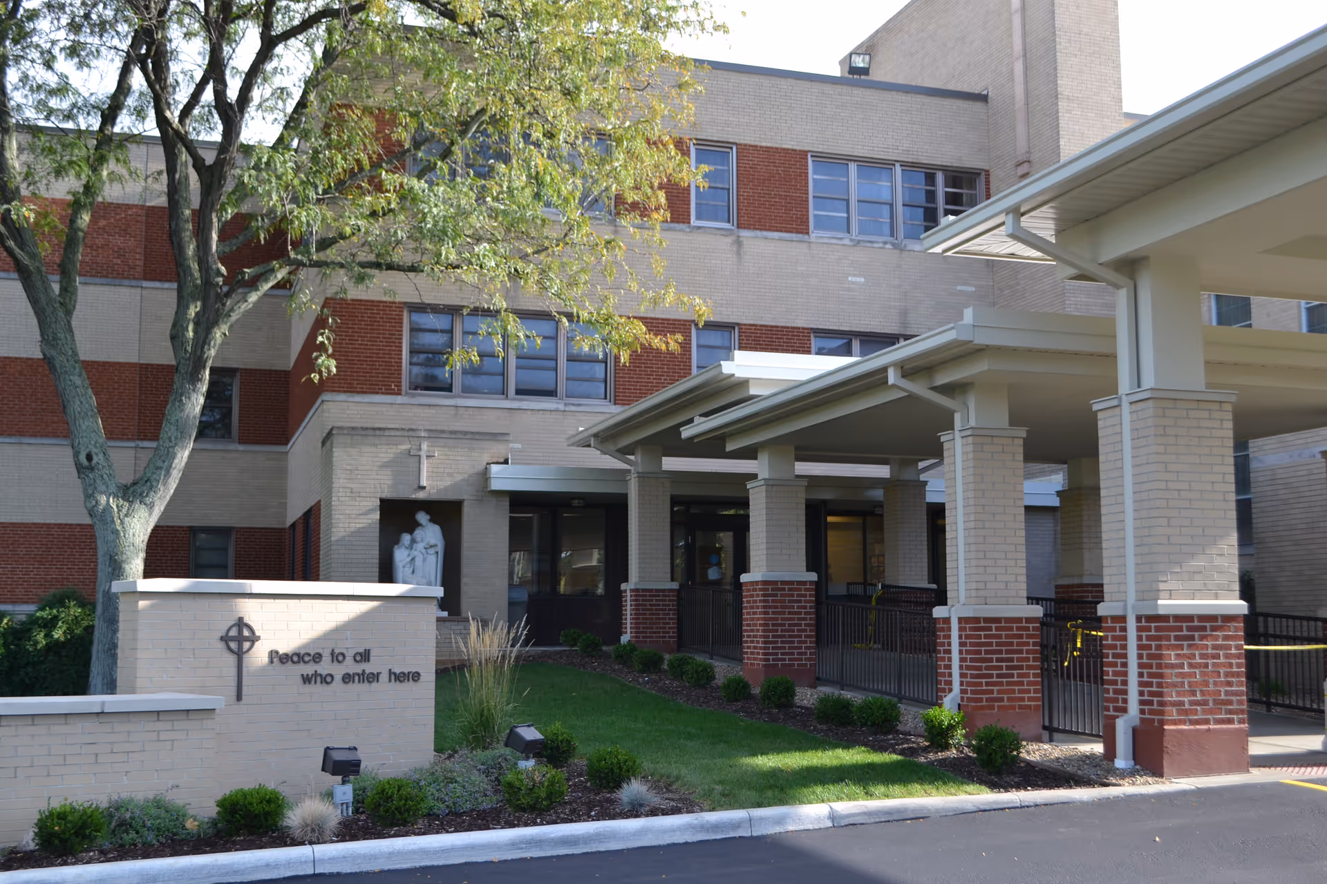 Exterior view of the facility entrance with a covered walkway and landscaped front