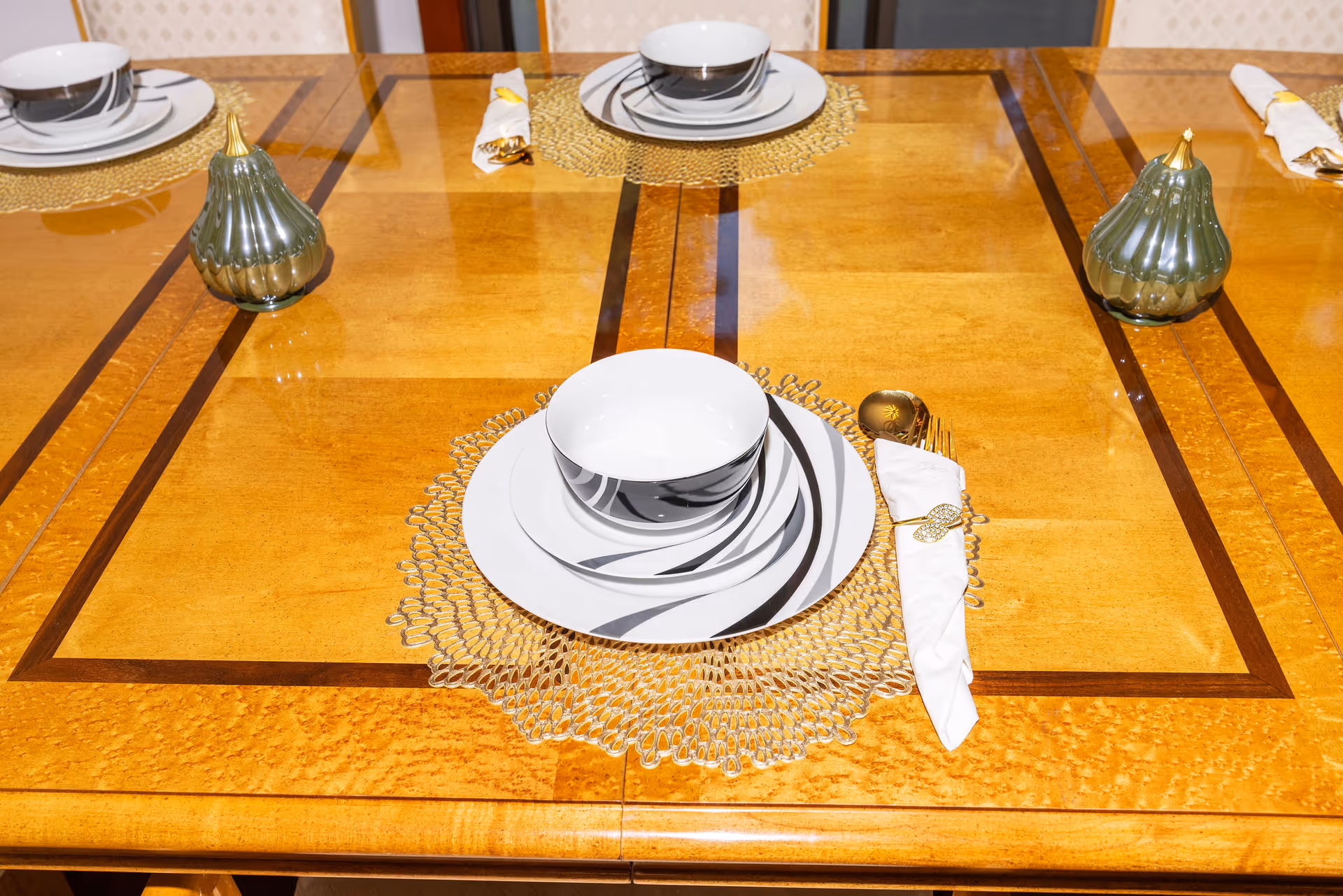 Wooden dining table set with plates, bowls, napkins, and decorative vases.
