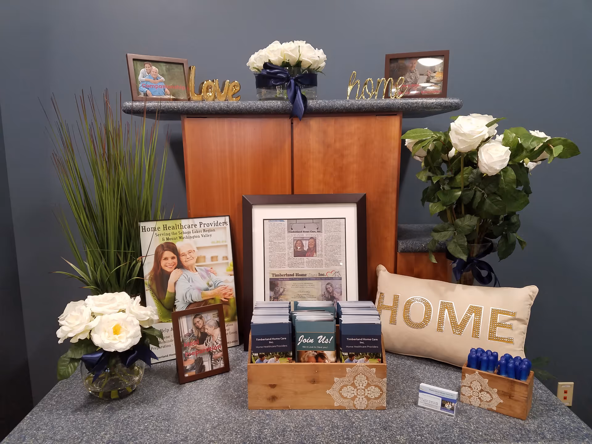 Reception desk with home-themed decor, plants, and brochures in Timberland Home Care.