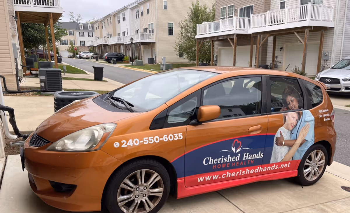 Orange Cherished Hands Home Health van parked on a residential driveway with people inside.