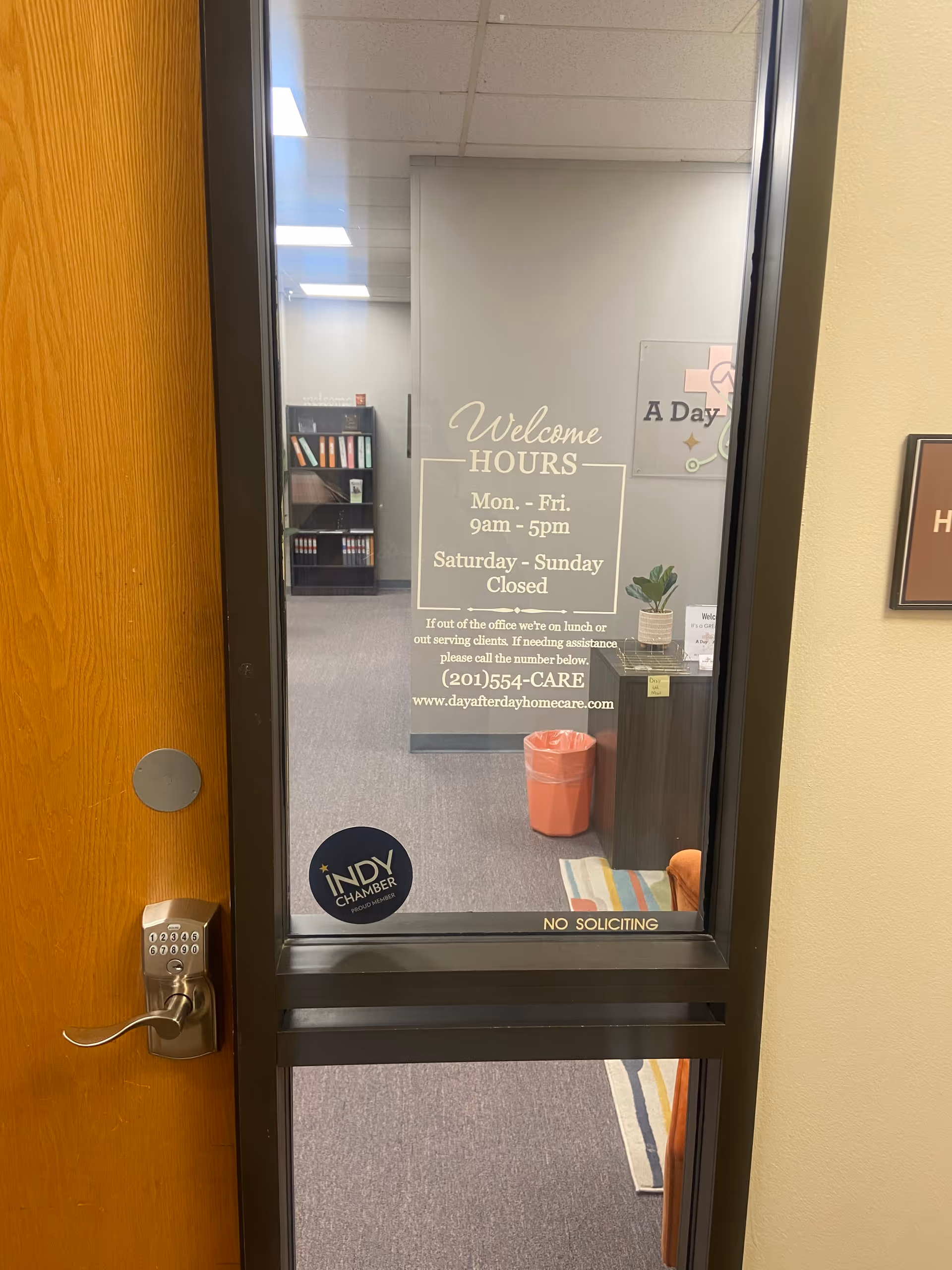 Interior office doorway with Welcome Hours sign and visible furniture inside.