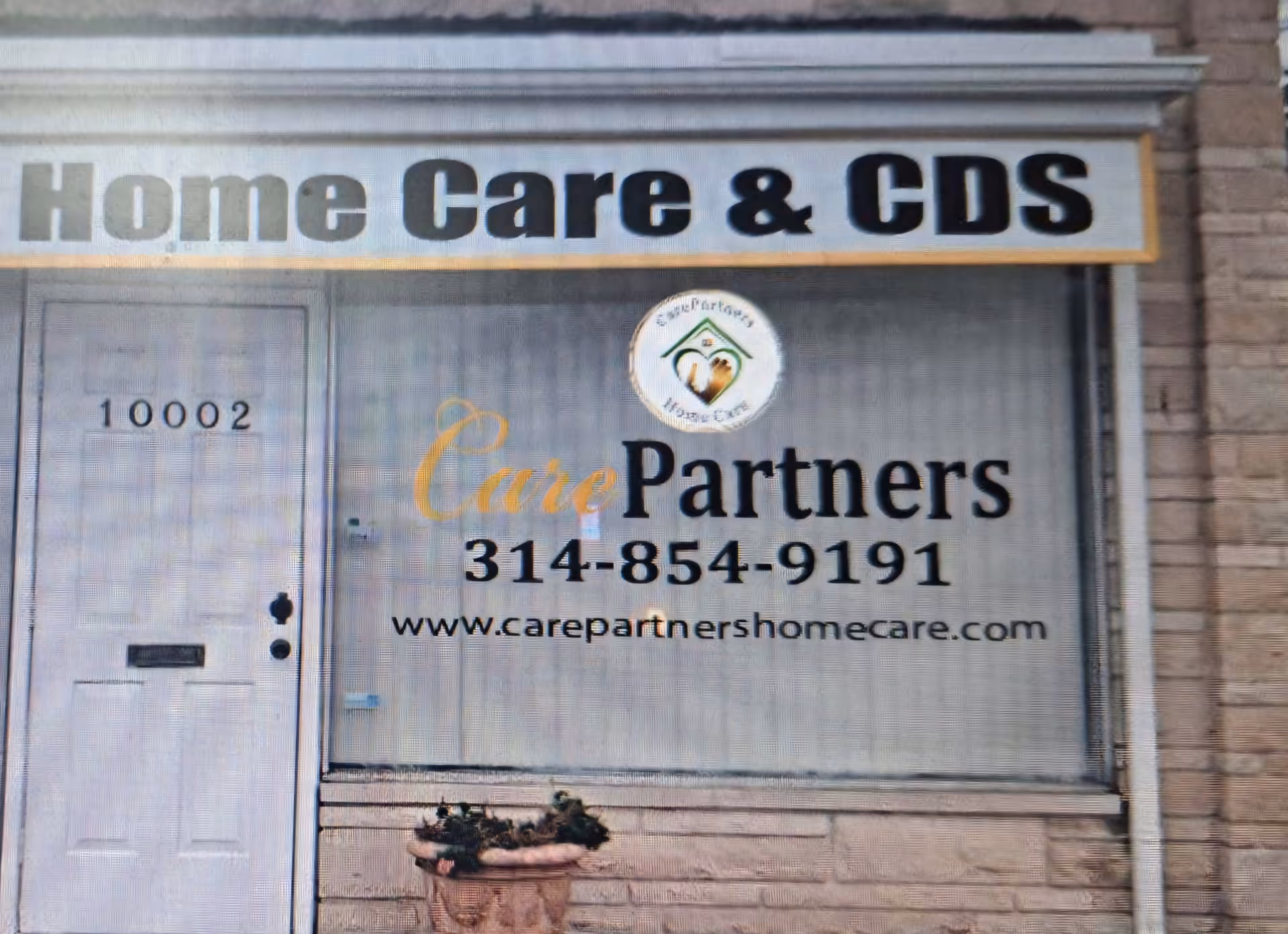 Exterior storefront with CarePartners Home Care sign, logo, and contact number.