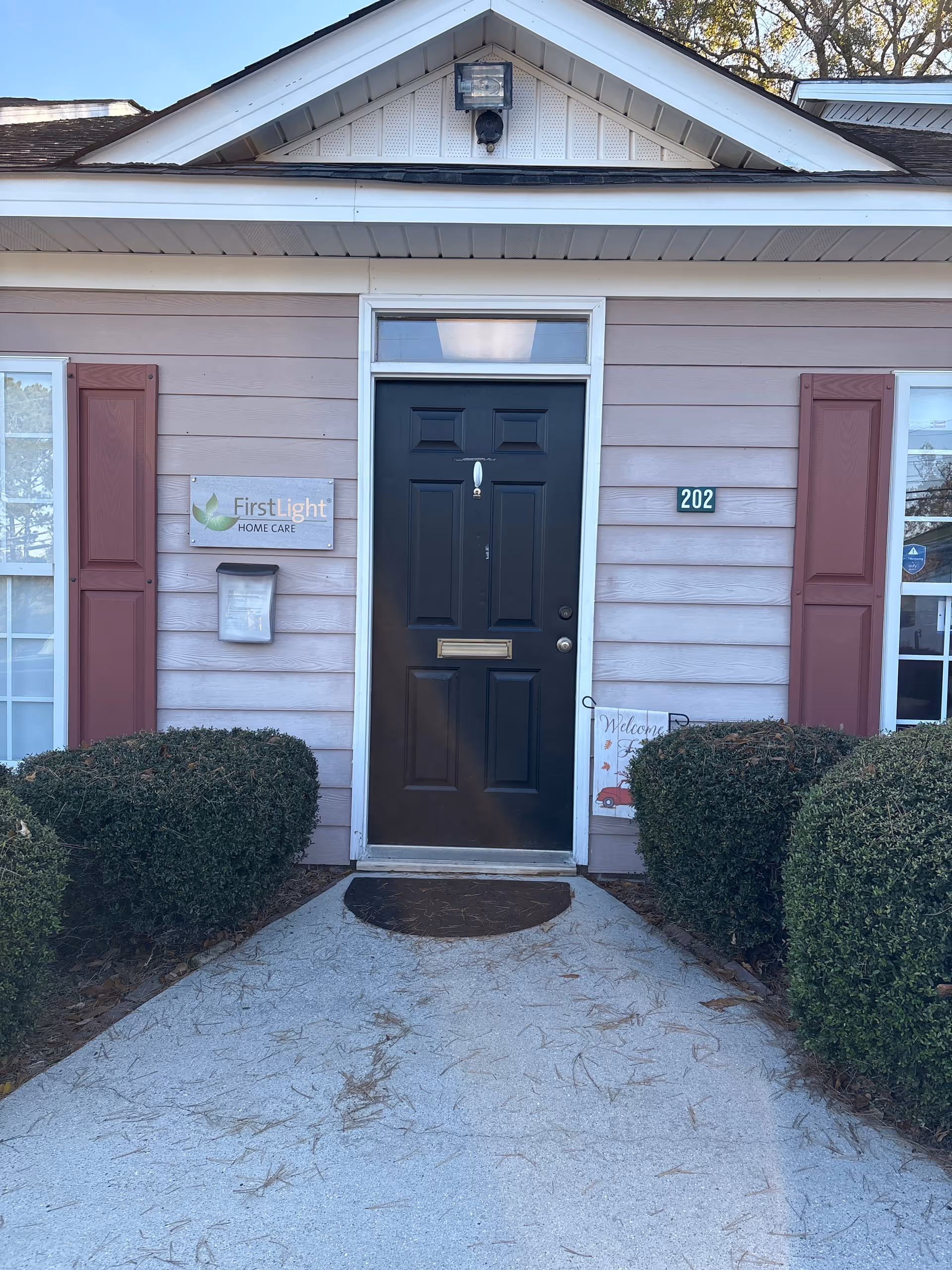 Front entrance of FirstLight Home Care Augusta with shrubs and welcome sign.