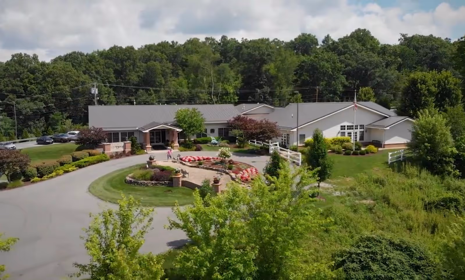 A senior living facility with a circular driveway and landscaped grounds.