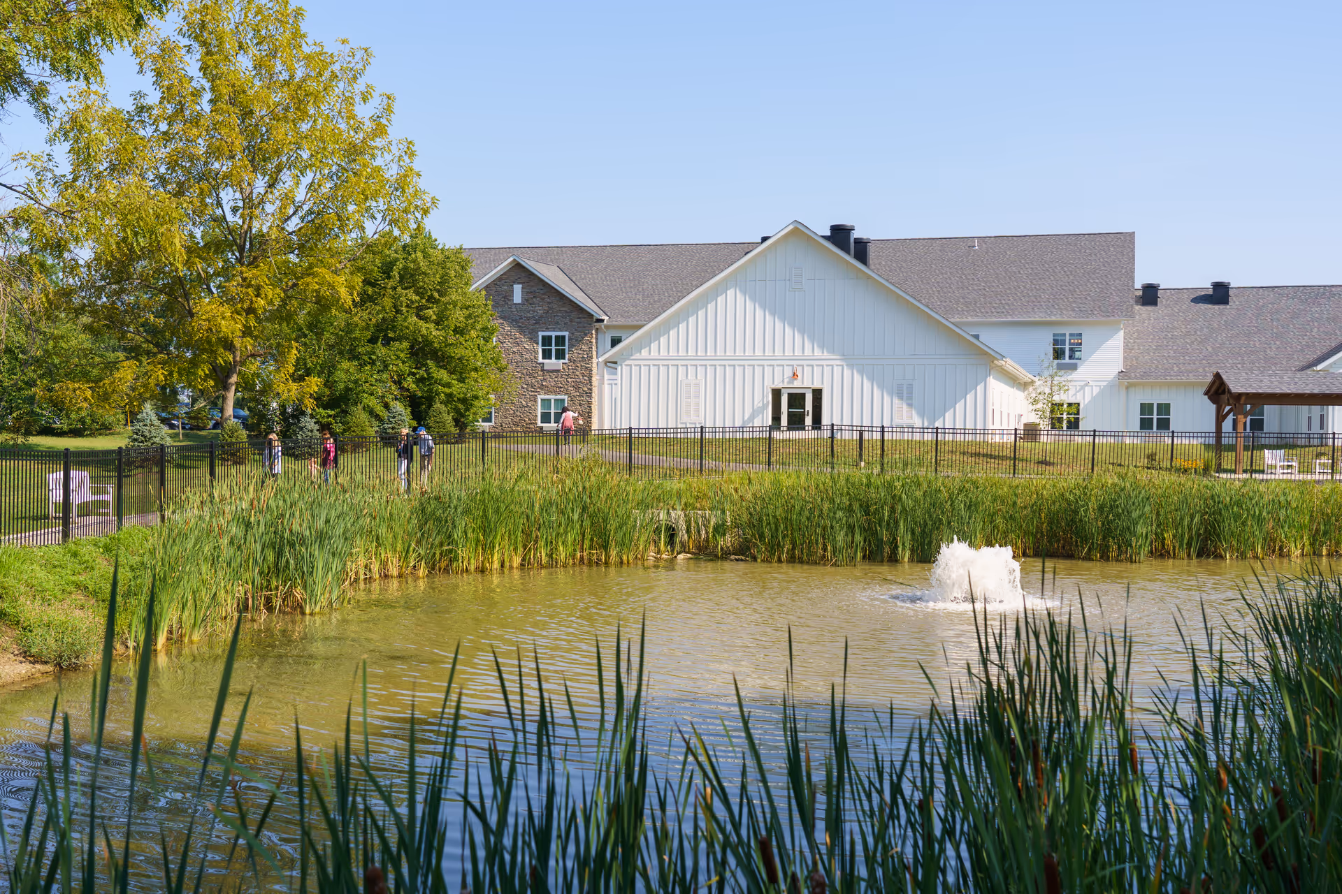 Exterior view of Canal Winchester Care Center with a pond, fountain, and greenery.